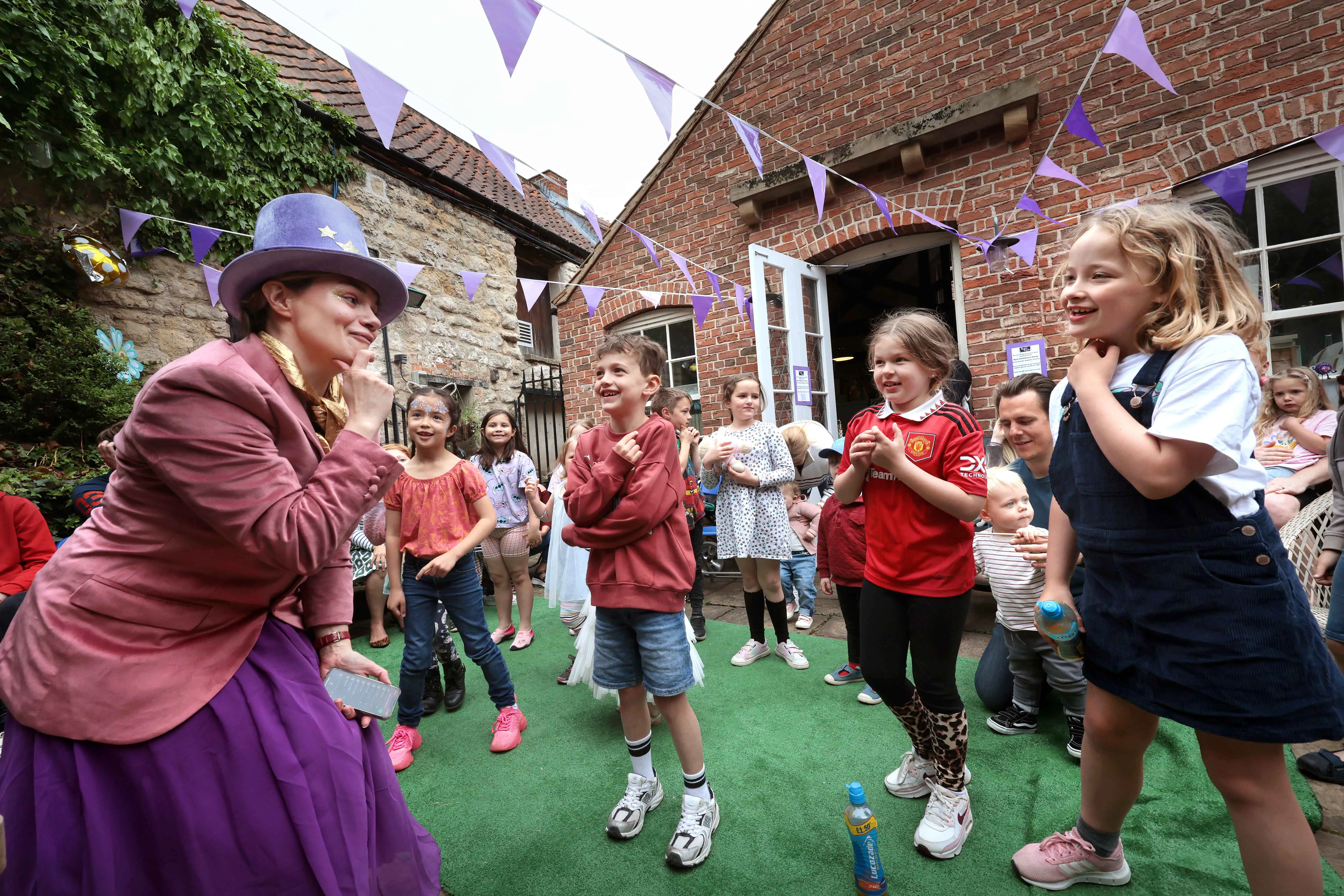 children's entertainer in a mary poppins style outfit playing games with children